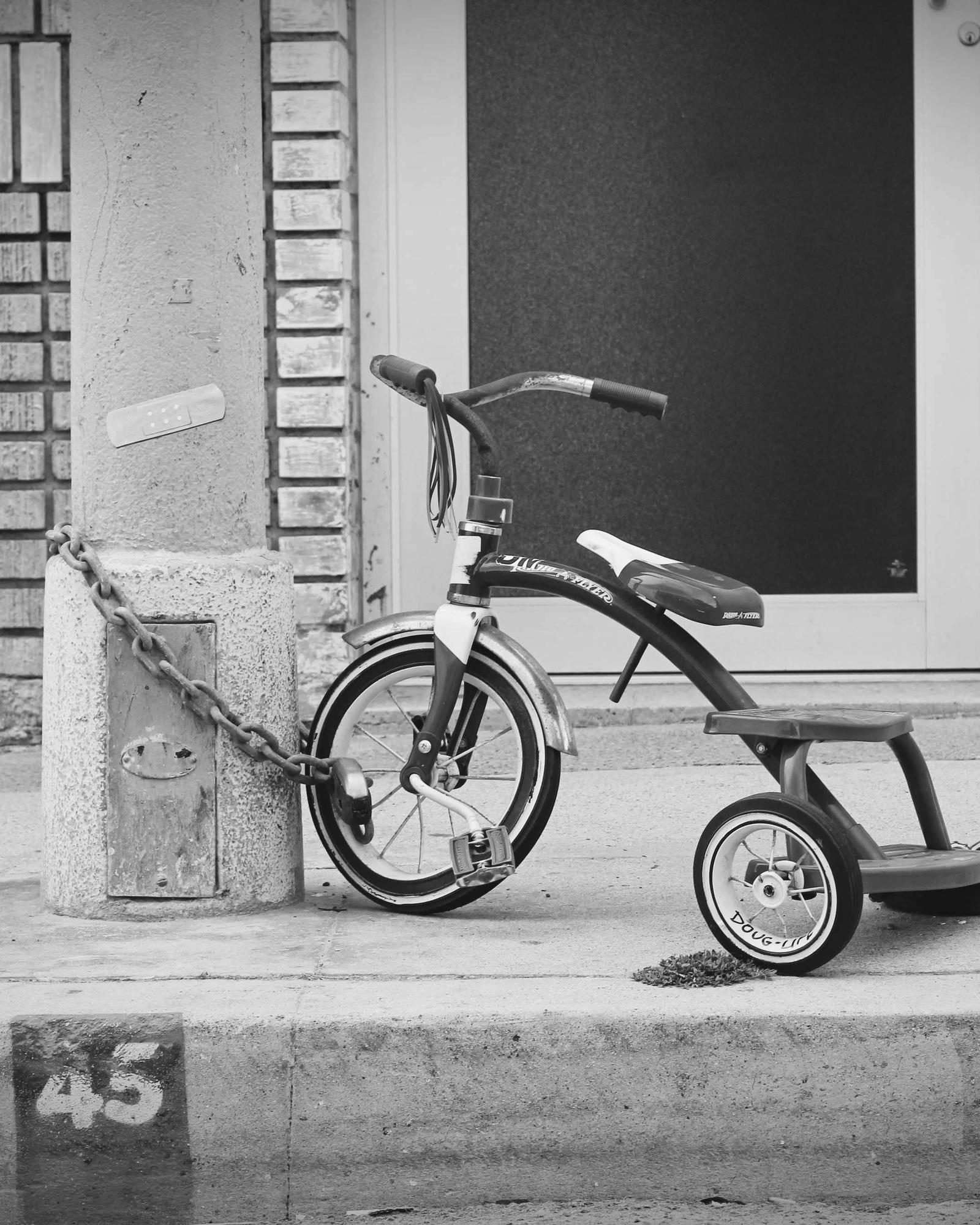 A doorway with a child's tricycle left outside it