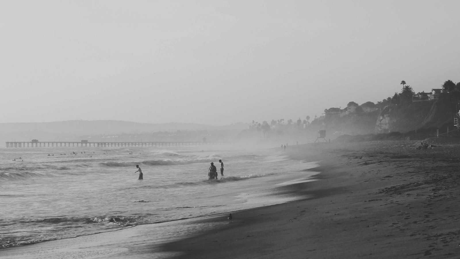 A wide empty shoreline with a single distant figure